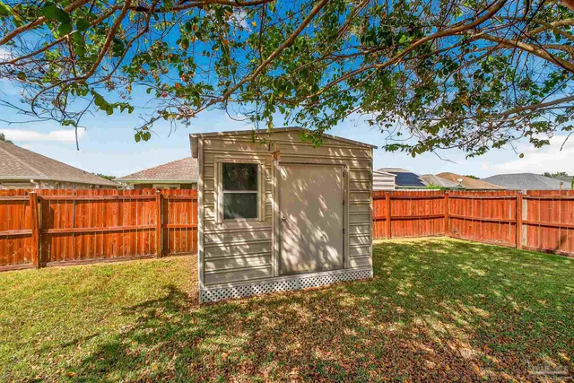 a view of a backyard with wooden fence