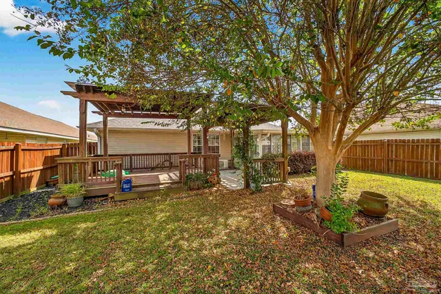 a view of a backyard with table and chairs and a large tree