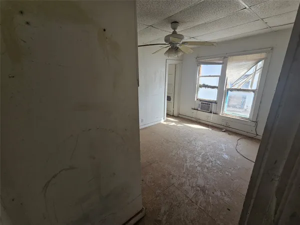 a view of a room with wooden floor and fan