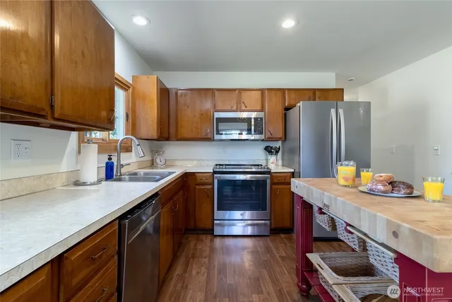 a kitchen with stainless steel appliances granite countertop a sink stove and refrigerator