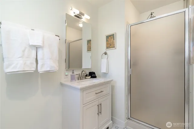 a bathroom with a sink mirror and a shower