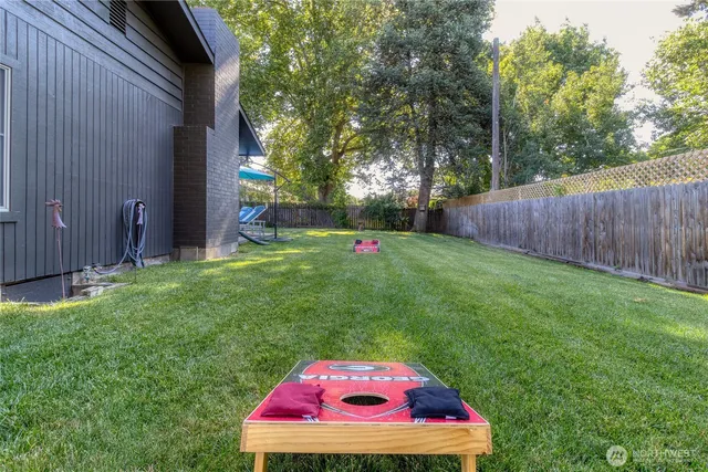 a view of a backyard with a small cabin and wooden fence