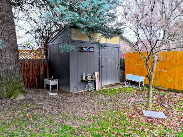 a backyard of a house with barbeque oven and table and chairs