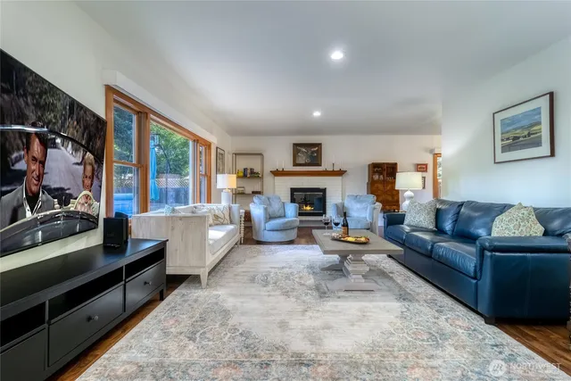 a living room with furniture fireplace and a large window