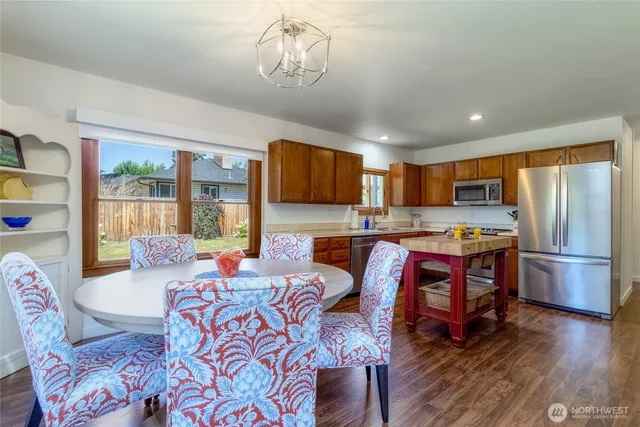 a living room with stainless steel appliances granite countertop furniture and a chandelier