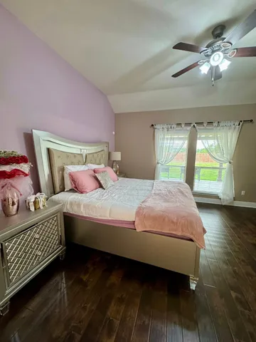 a bedroom with a bed and wooden floor