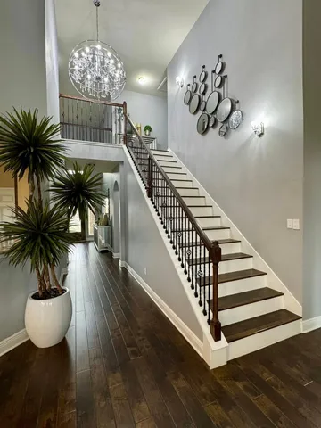 a view of a room with wooden floor chandelier and entryway