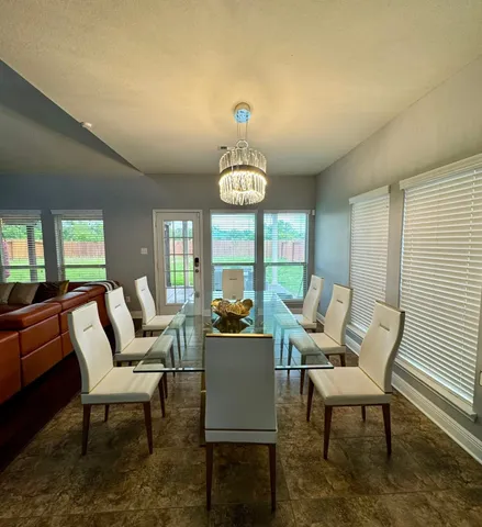 a dining room with furniture a rug and a large window