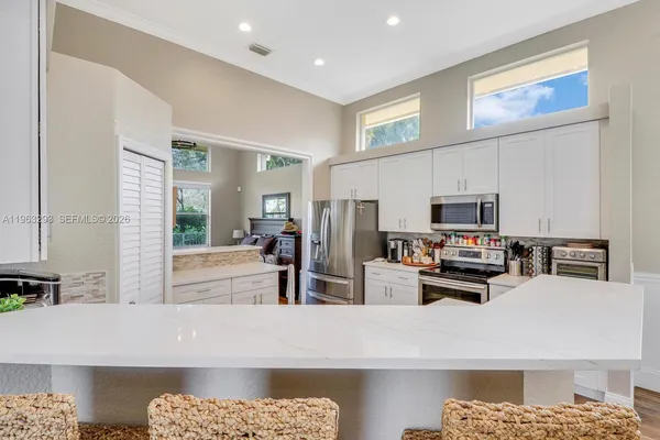 a kitchen with stainless steel appliances kitchen island granite countertop a refrigerator and a stove top oven