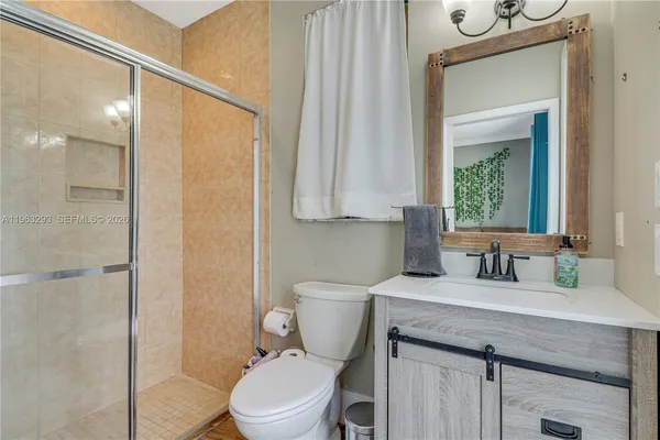a bathroom with a granite countertop sink a toilet and a mirror