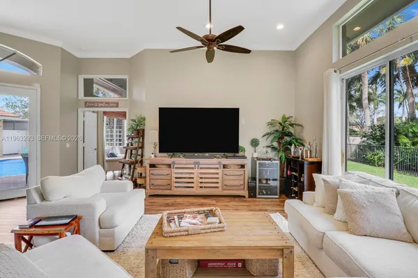 a living room with furniture a flat screen tv and a large window