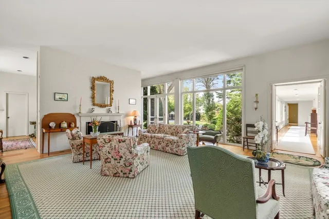 a living room with furniture fireplace and large windows