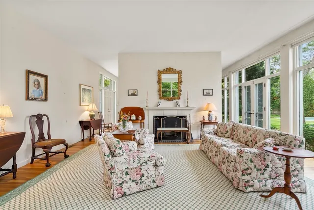 a living room with furniture fireplace and a large window