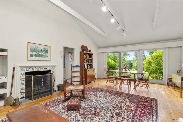 a living room with furniture a rug a fireplace and a large window