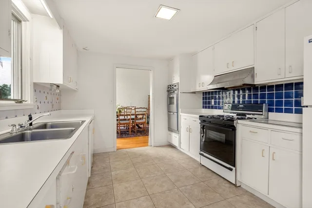 a kitchen with granite countertop a sink and a stove top oven