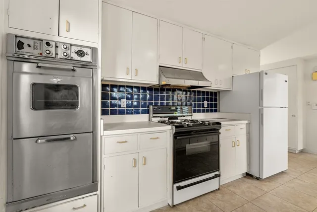 a kitchen with cabinets and stainless steel appliances