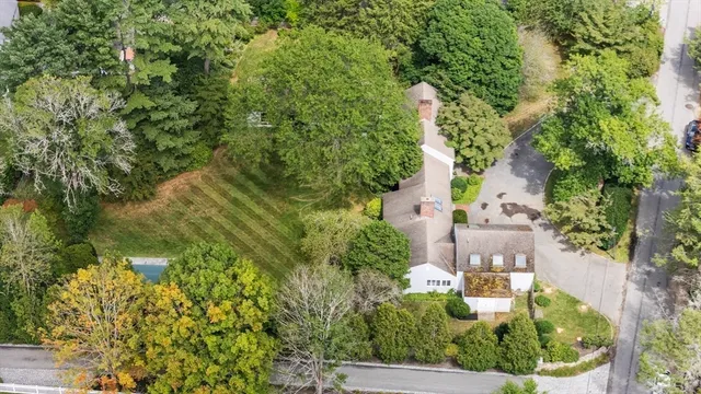 an aerial view of residential house with outdoor space and trees all around