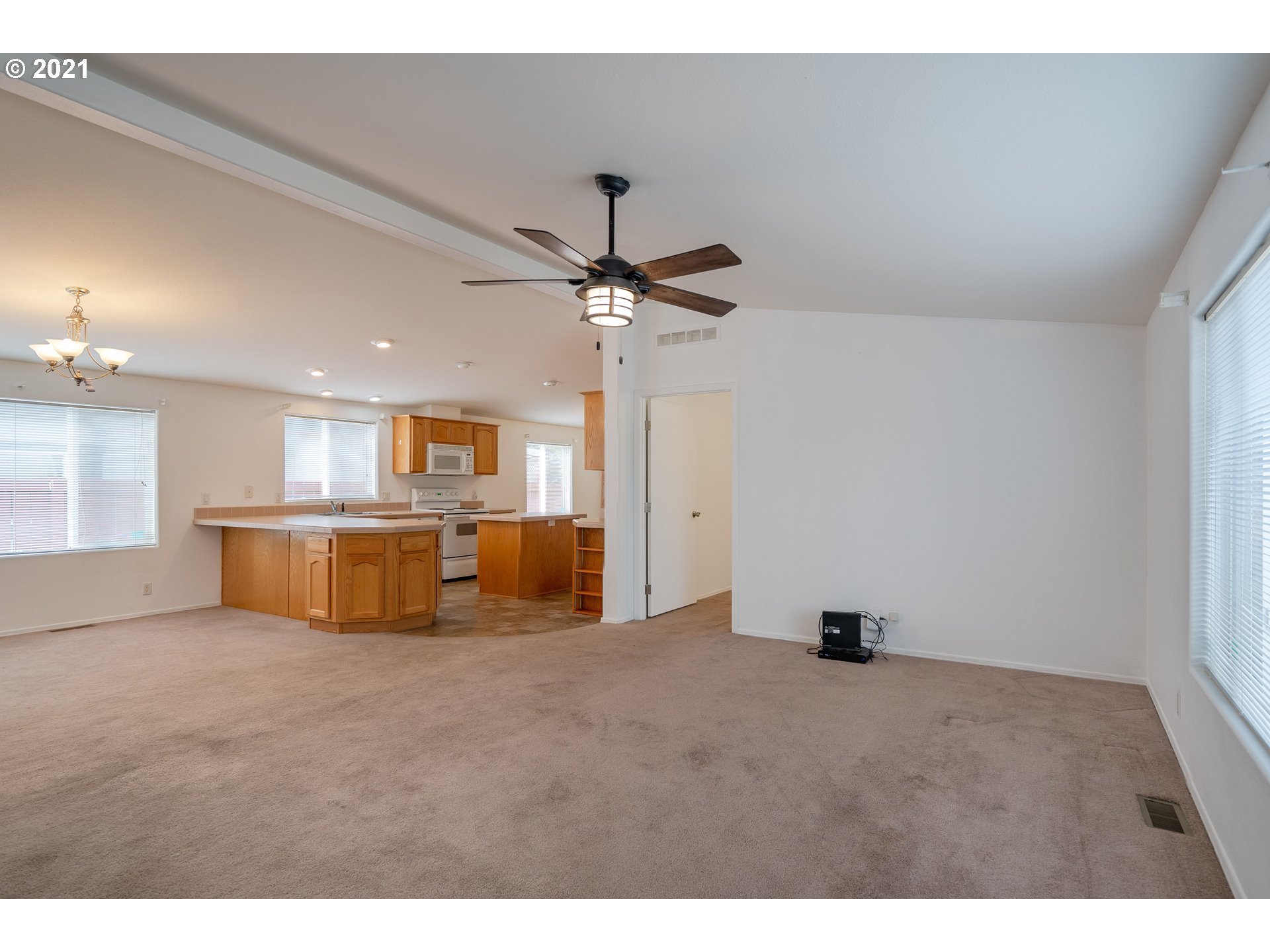 2525 Maia Loop Springfield, OR 97477 - Photo 3 of 27 a view of open kitchen with kitchen island a stove a sink dishwasher and a refrigerator with wooden floor