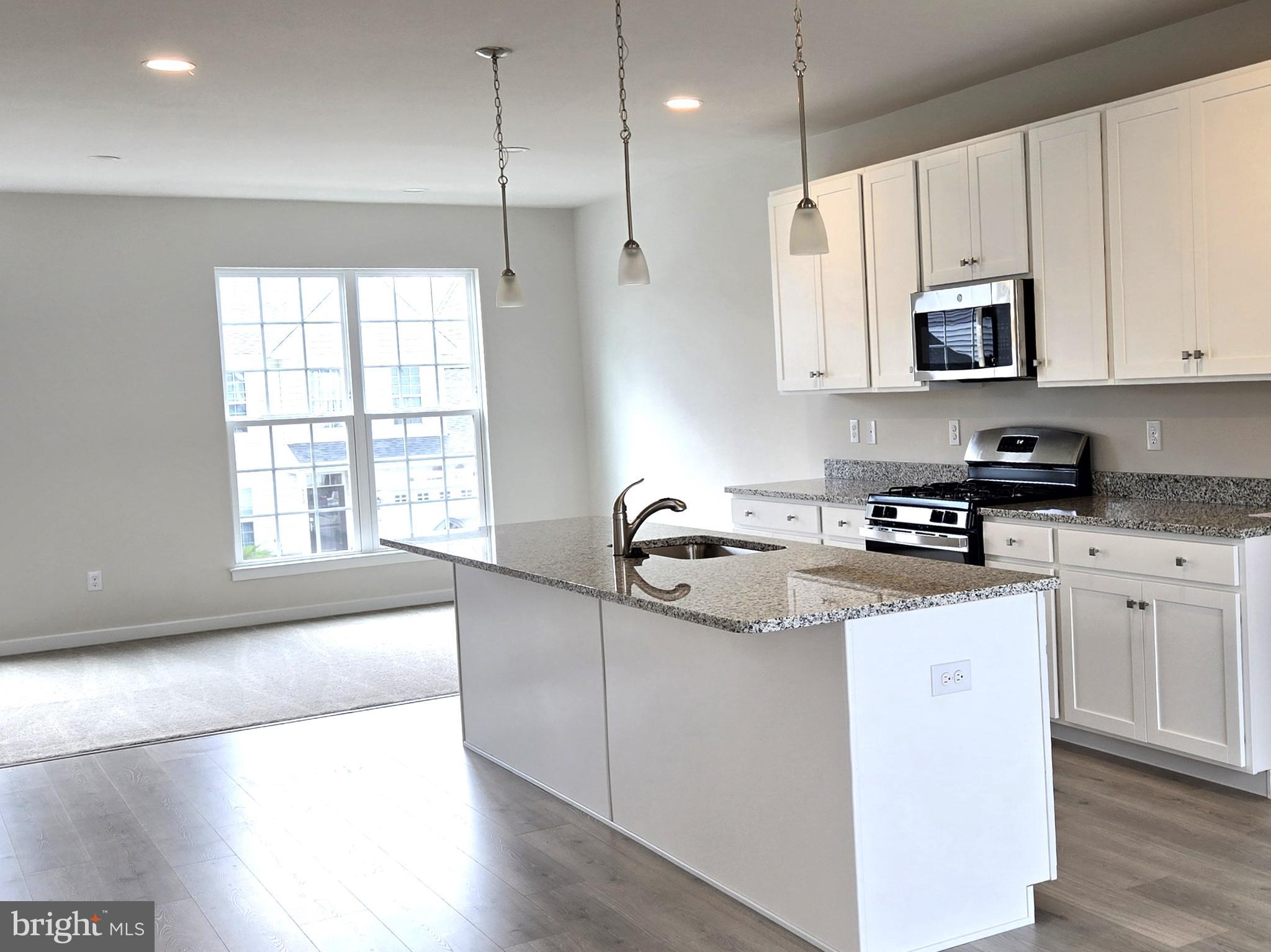 123 Case Road Townsend, DE 19734 - Photo 5 of 22 a kitchen with stainless steel appliances granite countertop a sink a stove a refrigerator and white cabinets with wooden floor