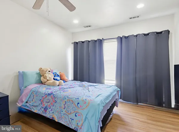 a bedroom with bed and wooden floor