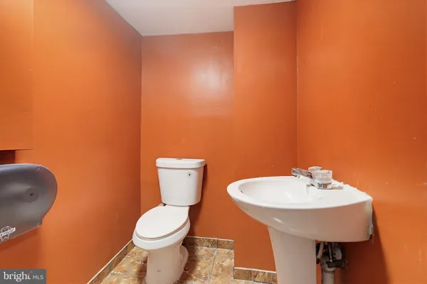 a bathroom with a toilet a sink and a mirror