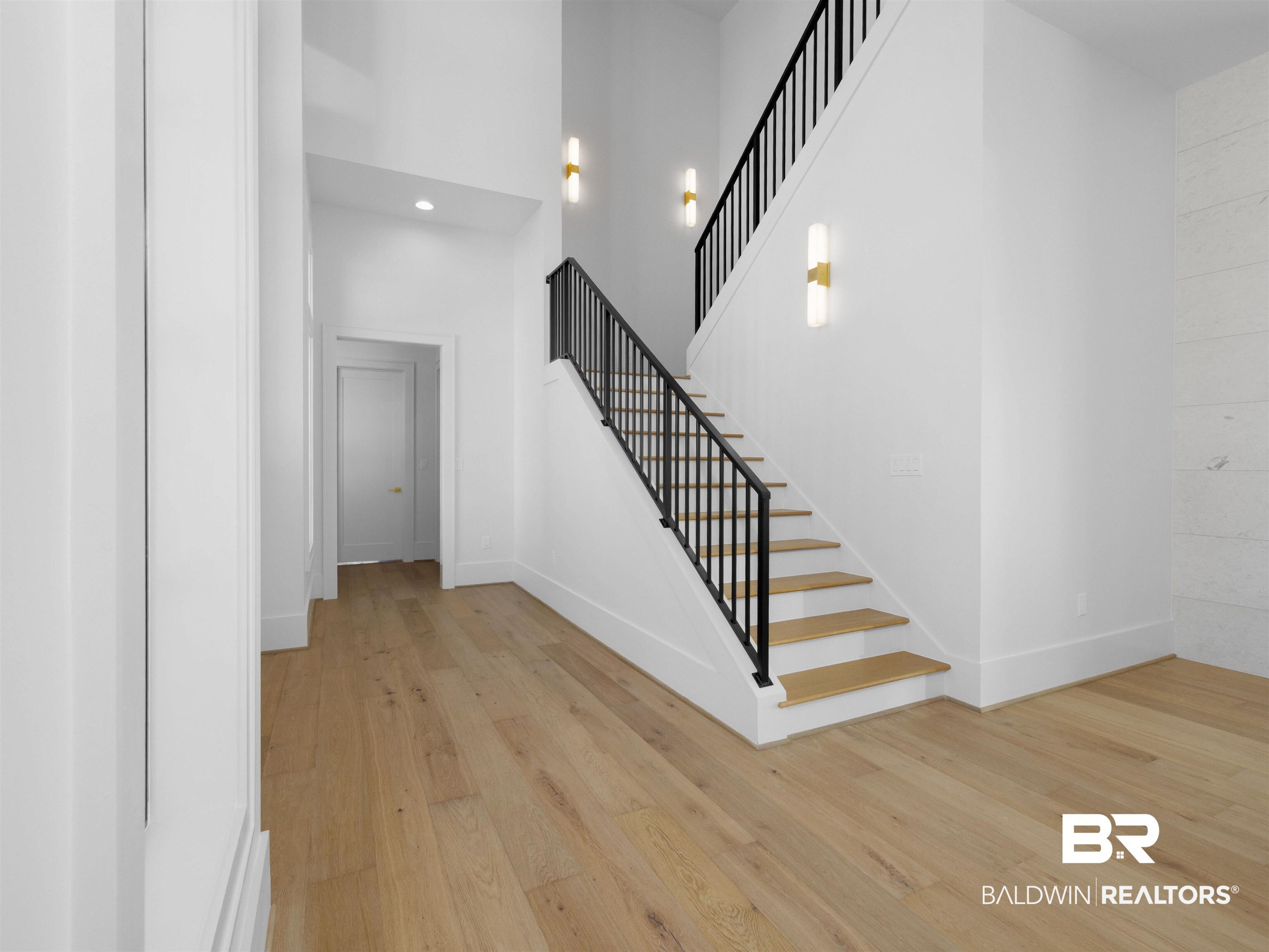 31292 River Road Orange Beach, AL 36561 - Photo 15 of 48 Stairs featuring recessed lighting, a towering ceiling, baseboards, and wood finished floors