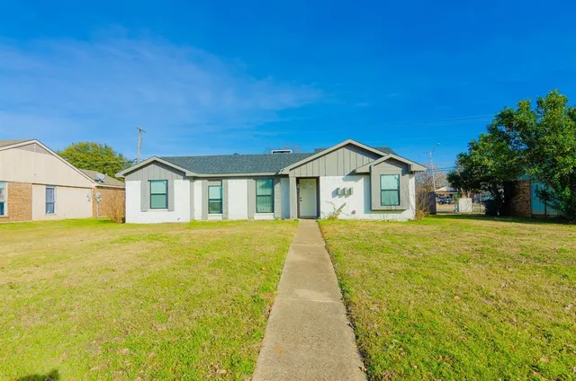 a view of a house with a yard and wooden fence