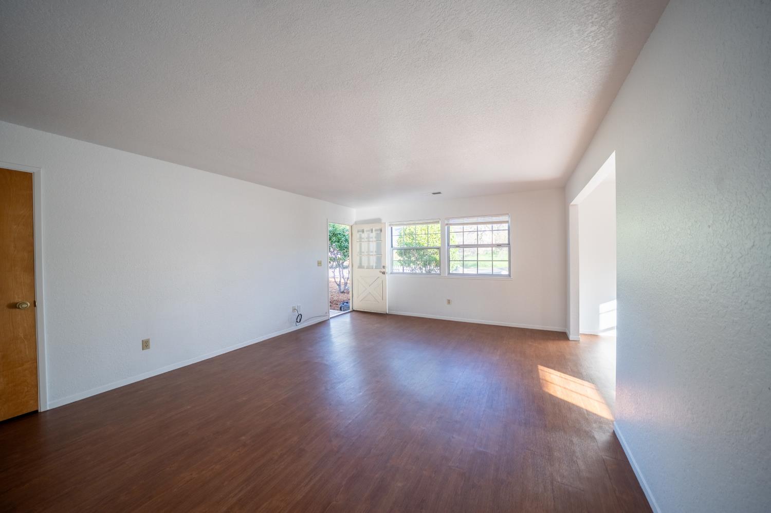 494 Surrey Court Murphys, CA 95247 - Photo 32 of 76 an empty room with wooden floor and windows