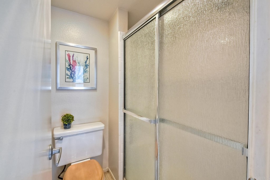 1808 Parliament Road Encinitas, CA 92024 - Photo 25 of 49 a bathroom with a toilet and a shower curtain