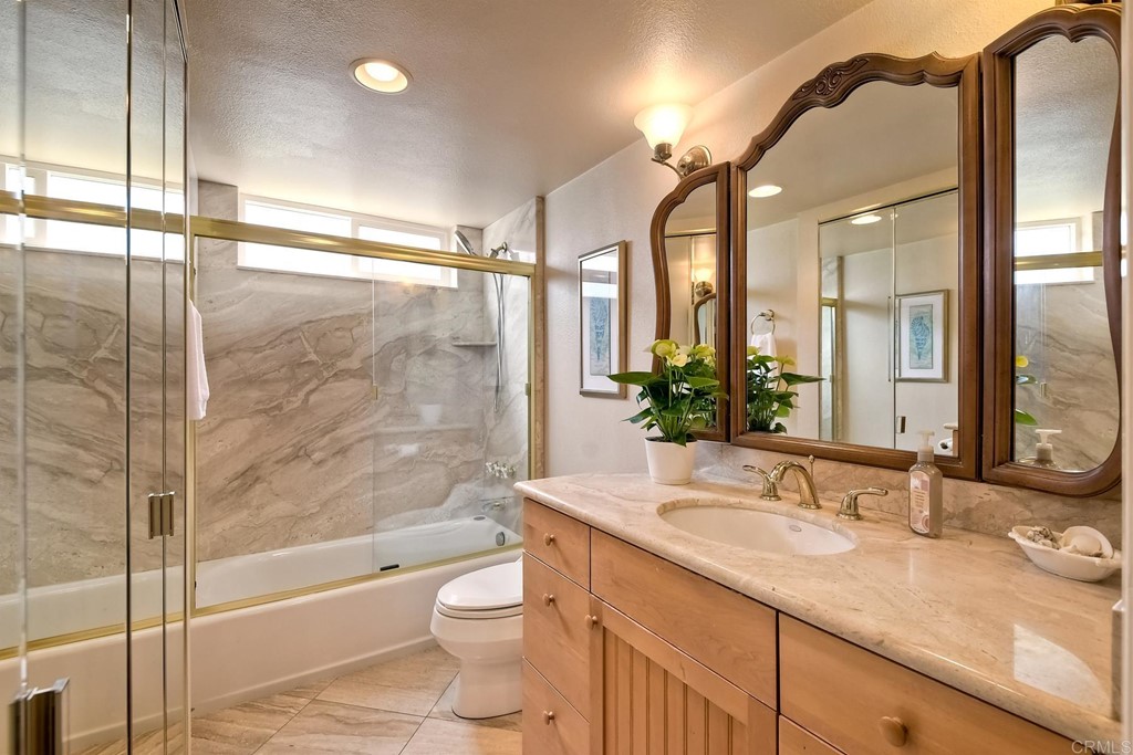 1808 Parliament Road Encinitas, CA 92024 - Photo 32 of 49 a bathroom with a granite countertop sink a toilet and shower
