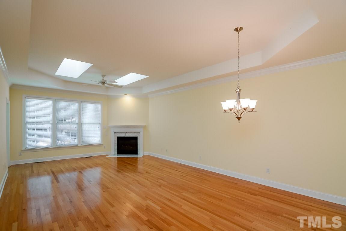 3504 Proprietor Way Raleigh, NC 27612 - Photo 11 of 25 a view of an empty room with wooden floor fireplace and a window