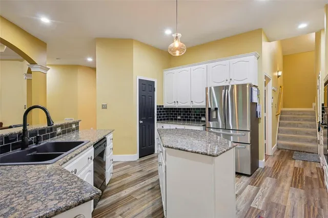 a kitchen with stainless steel appliances granite countertop a sink stove and refrigerator