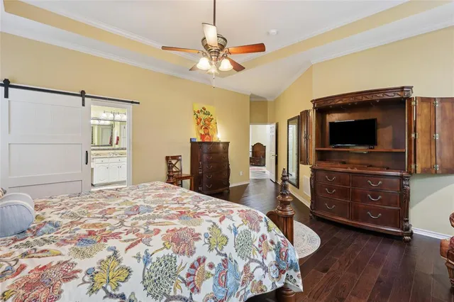 a bedroom with a bed and a flat tv screen on dresser