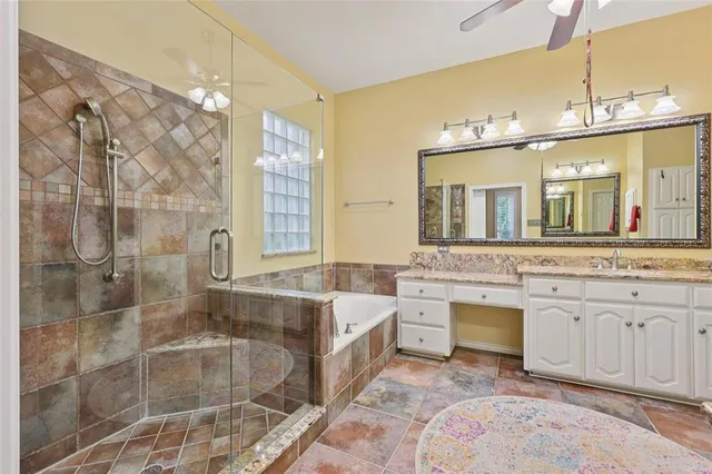 a spacious bathroom with a granite countertop sink a mirror and a bathtub