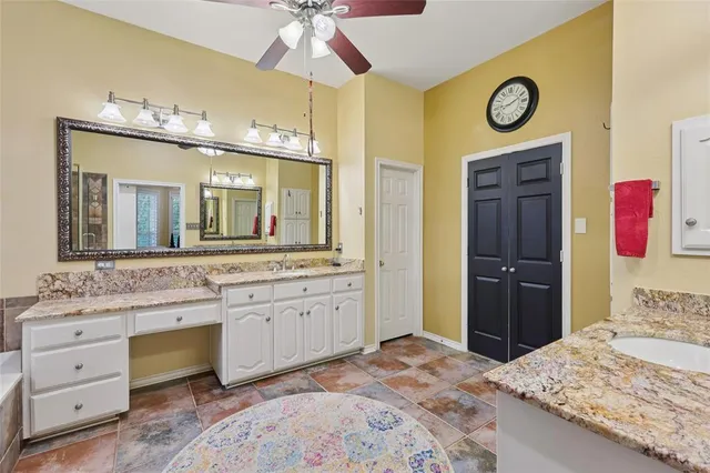 a spacious bathroom with a granite countertop sink and a mirror