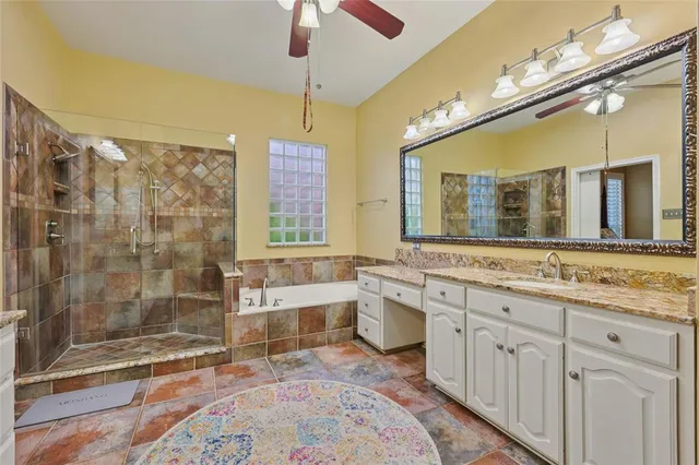 a spacious bathroom with a granite countertop sink mirror and shower
