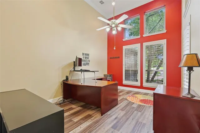 a living room with furniture a large window and wooden floor
