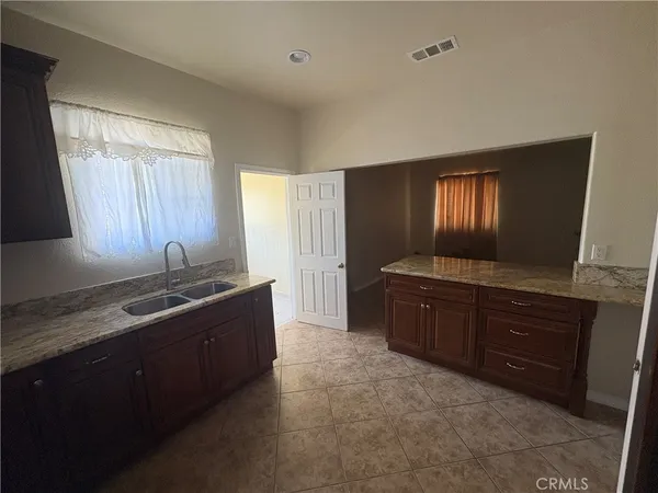 a spacious bathroom with a granite countertop sink a mirror and a bathtub
