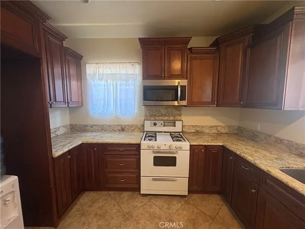 a kitchen with stainless steel appliances granite countertop a stove microwave and sink