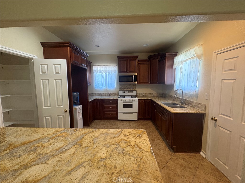 3395 Franklin Avenue Riverside, CA 92507 - Photo 21 of 55 a kitchen with stainless steel appliances granite countertop a sink refrigerator and cabinets