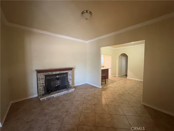 a view of an empty room with a fireplace and a window
