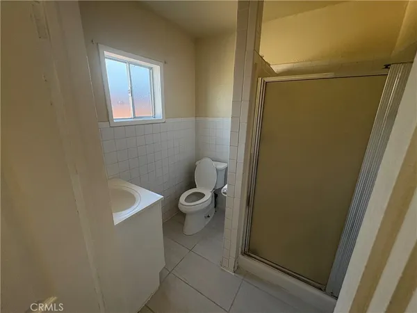 a bathroom with a granite countertop toilet and a sink
