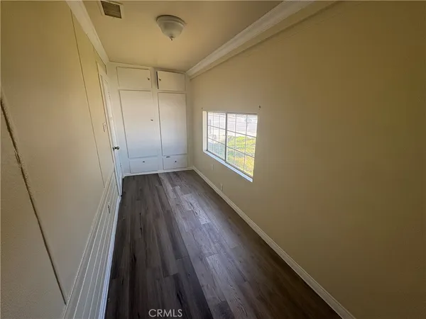 a view of hallway with a wooden floor and a floor to ceiling window