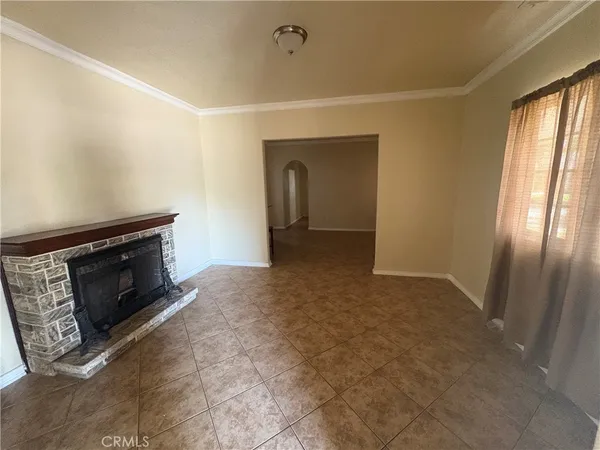 a view of an empty room with a fireplace and a window