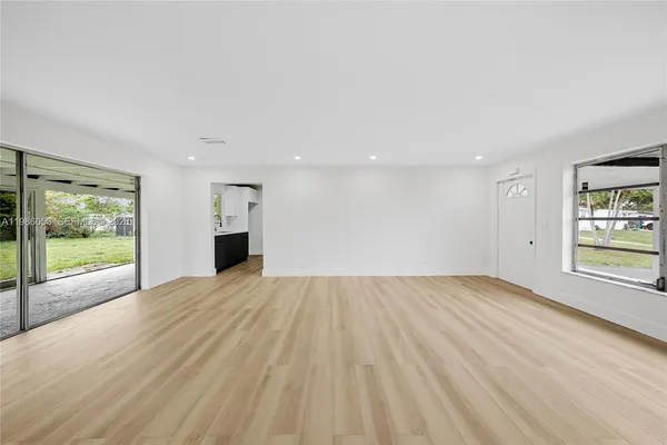 a view of empty room with wooden floor and fireplace