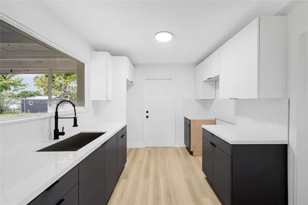 a kitchen with a sink dishwasher and a stove with wooden floor
