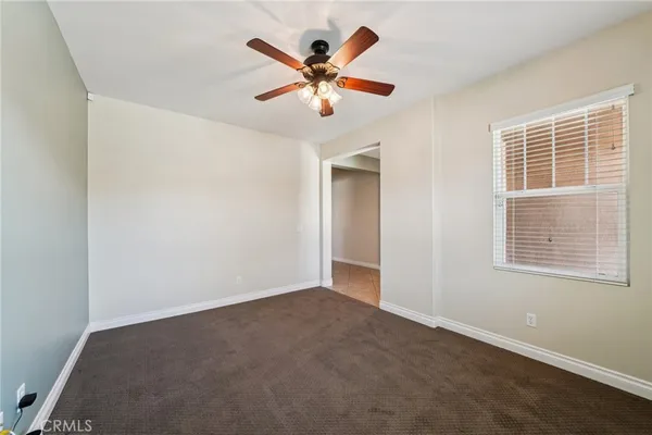 an empty room with window and ceiling fan