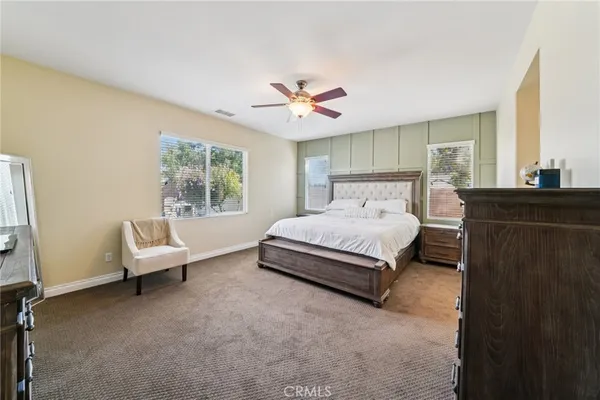a spacious bedroom with a bed couch and window