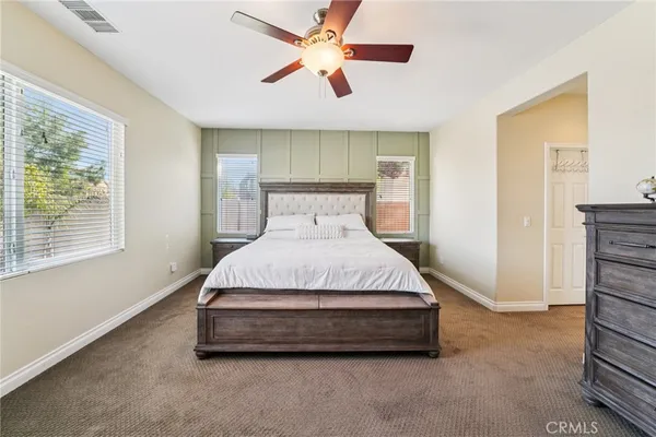 a spacious bedroom with a bed and a chandelier