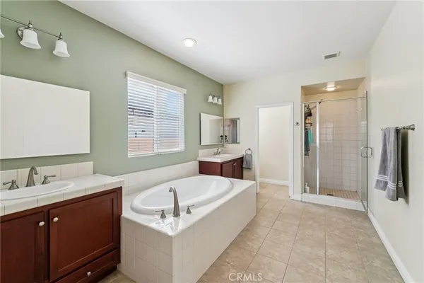 a spacious bathroom with a tub sink and mirror